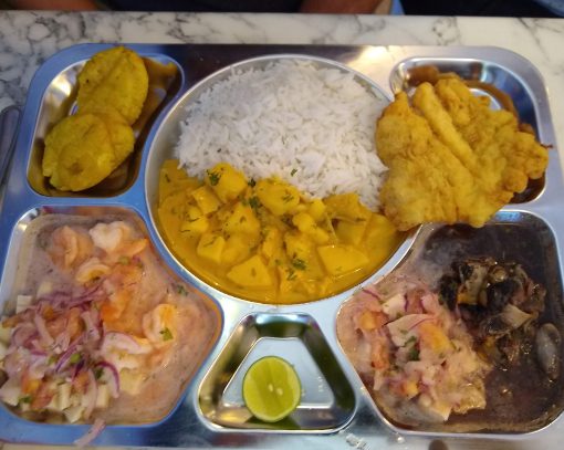 Una Bandeja de La Yapa Una Bandeja de La Yapa incluye cuatro platos diferentes de marisco, arroz y patacón