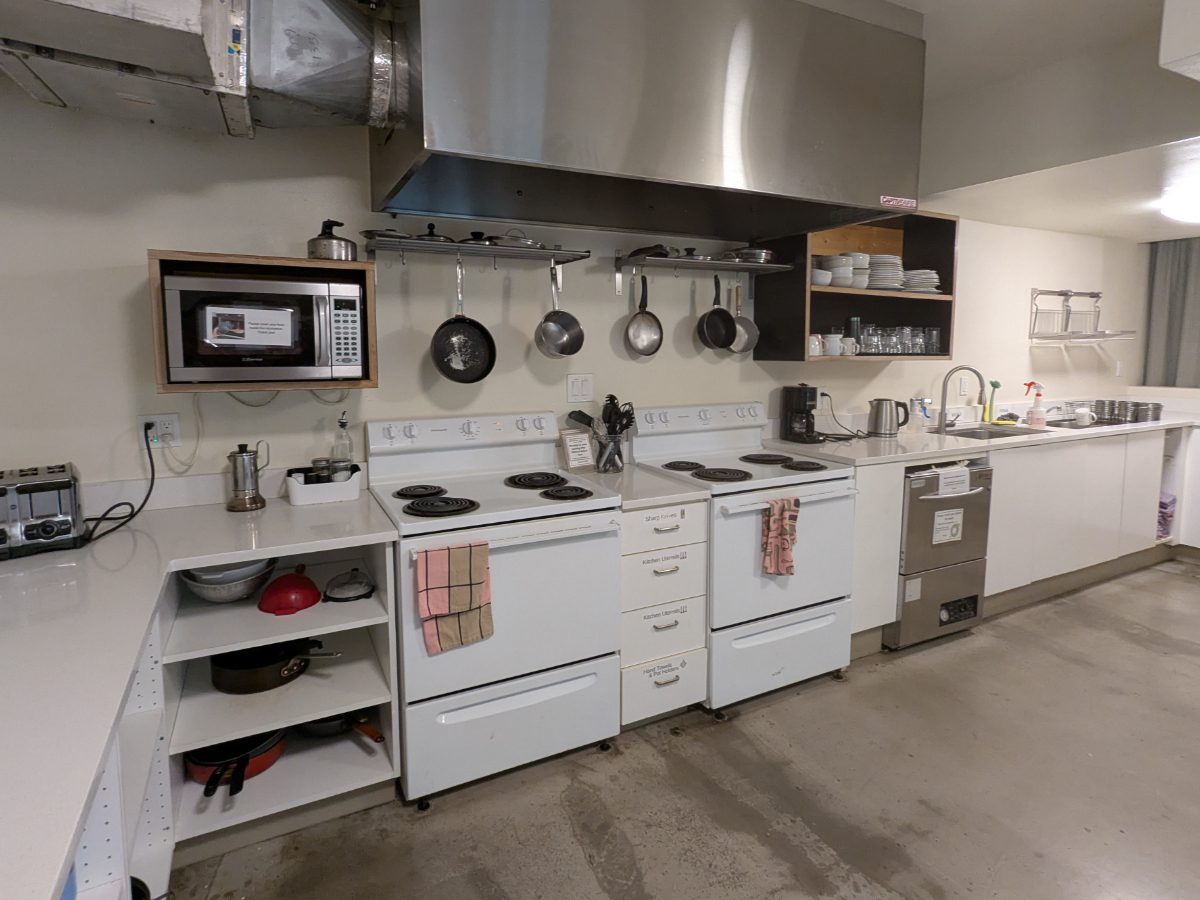 Communal Kitchen at the NW Portland Hostel includes stove, refrigerators, sink, pots, pans, utensils, dishes, and more.