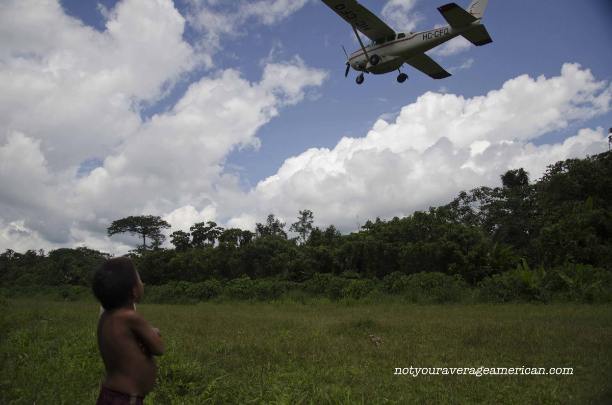 A Huaorani child watches as Alas de Socorro takes off, Huaorani Lodge A Huaorani child watches as Alas de Socorro takes off, Huaorani Lodge