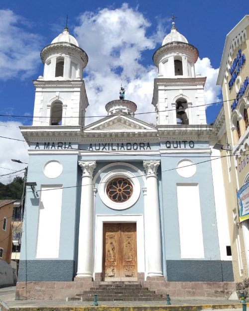 Iglesia de Maria Auxiliadora, Barrio La Tola, Quito, Ecuador | ©Jacqueline Granda Marcillo Colonial style church painted in light blue with white accents, wooden door, rose window, and two white towers