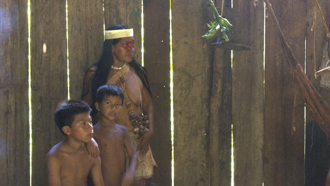 A Huaorani women in traditional class and two young Huaorani boys with bare chests