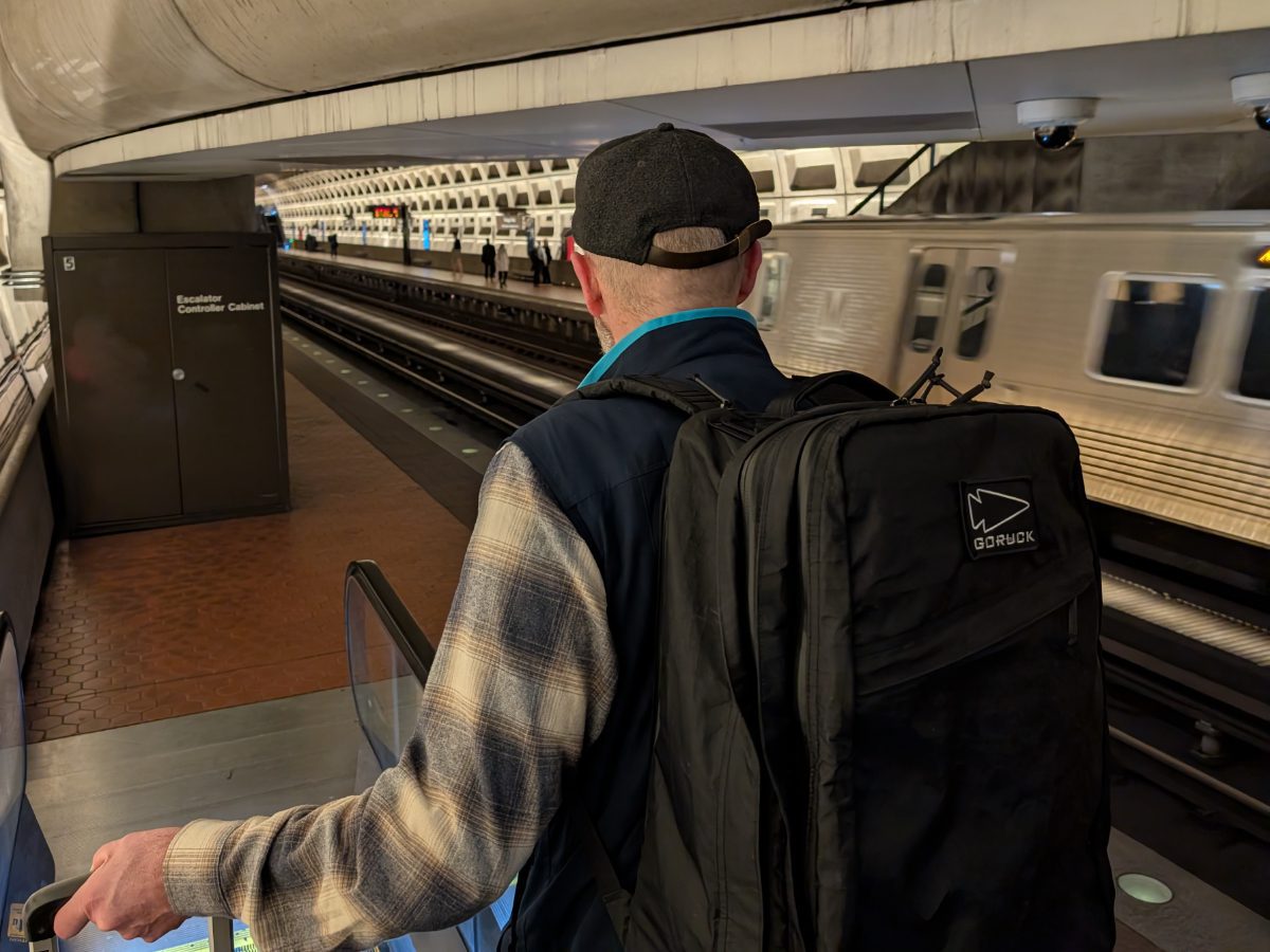 Man wearing a GORUCK backpack as he steps off the escalator in the DC Metro
